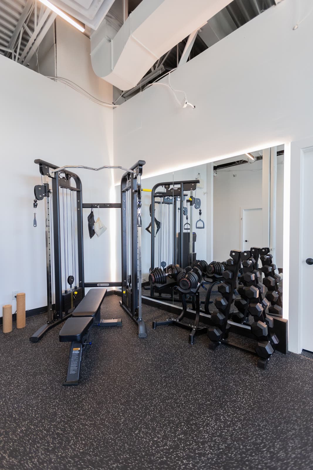Open rehab gym with a cable machine and free weights