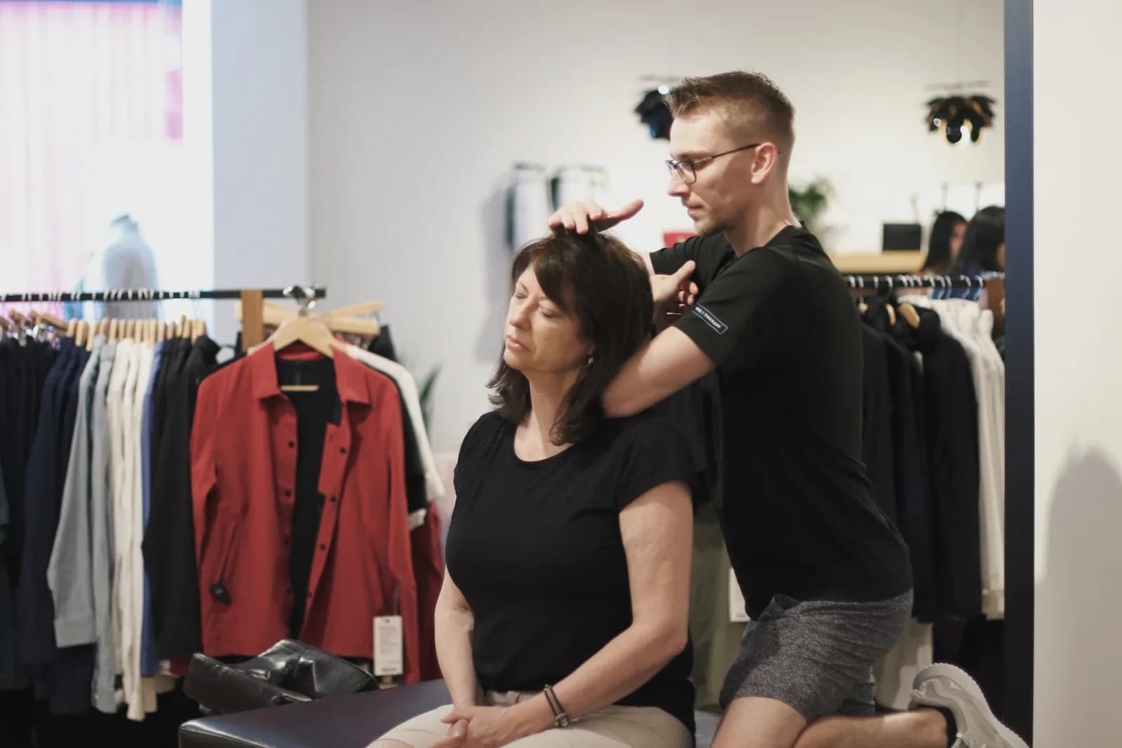 PRE Therapy practitioner treating a guest's neck and shoulders at a lululemon community event.